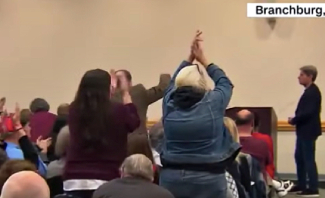 Watch As Town Hall Audience Break Into Applause After Lawmaker Announces He Will Vote For Trump’s Impeachment